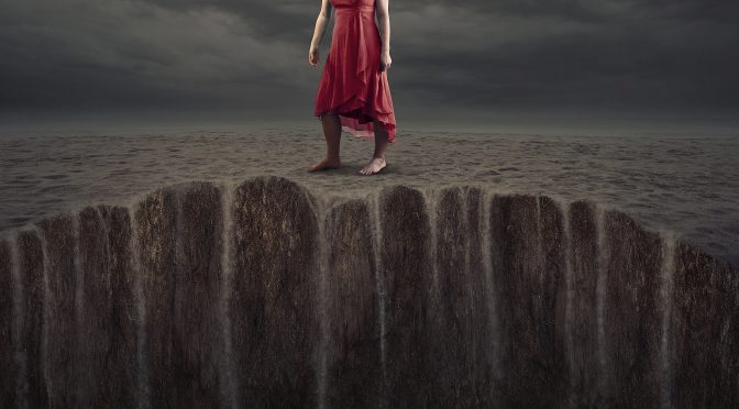 A woman standing on sand that is sinking.