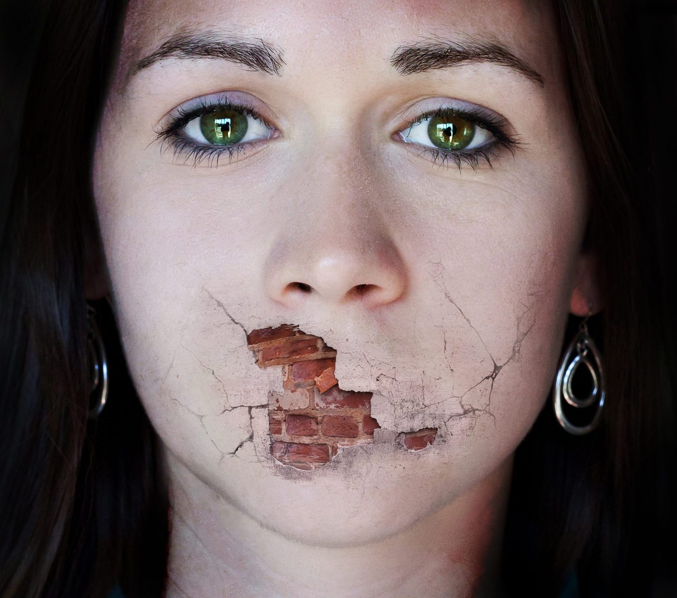 A woman tries to speak but her mouth is a broken brick wall.